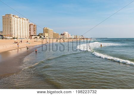 VIRGINIA BEACH, VIRGINIA - JULY 13, 2017:  People enjoy beach-front leisure activities on the south end of the 3-mile oceanfront lined with high-rise hotels.