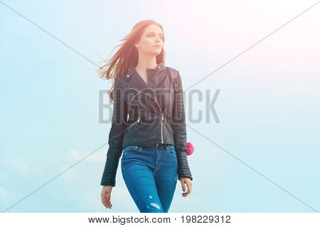 Woman with long hair. Girl in leather jacket. Beauty and fashion. Sexy woman outdoor. Fashion model on blue sky.
