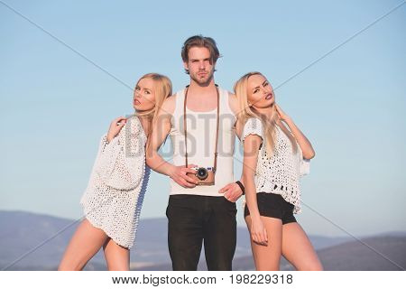 Love and romance. Guy with photo camera on athletic chest. Beauty and art fashion. Man with muscular body with twins. Girl and women with photographer outdoor.