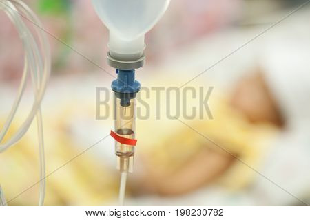 Close up saline IV drip for patient and Infusion pump in hospital In the hospital with a fragment of medical equipment and patients boy High fever for bacterial infections.