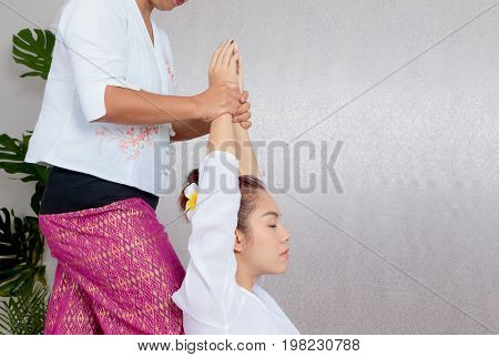 Asian Woman Getting Traditional Thai Stretching Massage By Therapist
