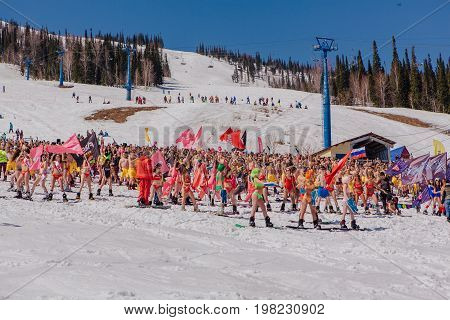 Group Of Young Happy Pretty Women On A Snowboard In Colorful Bikini With Flags.
