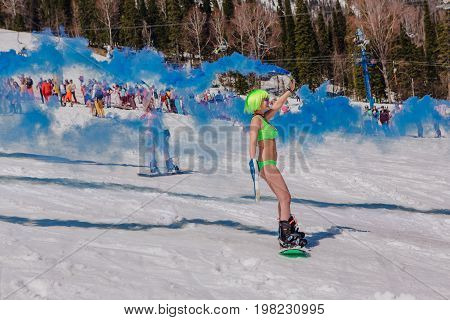 Group Of Young Happy Pretty Women On A Snowboard In Colorful Bikini With Flags.