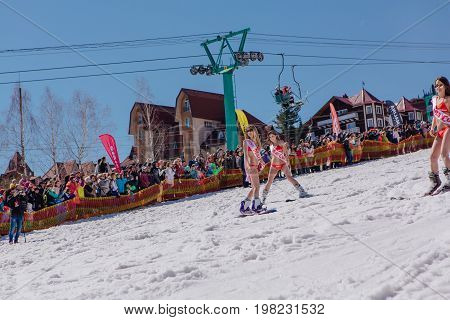 Sheregesh, Kemerovo region, Russia - April 22, 2017: Grelka Fest is a sports and entertainment activity for ski and snowboard riders in bikini. Group of young women on a snowboard in colorful bikini.