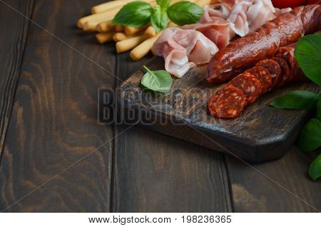 Chorizo sausage. Spanish traditional chorizo sausage and ham with fresh herbs and tomatoes.