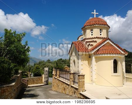 One of the buildings of the monastery in the village of Spili on the island of Crete and the street next to it