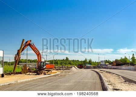 Crawler Excavator to hammer a steel piles into ground. Construction of high-speed bypass road around Krasnoe Selo Saint Petersburg. Heavy machine equipment for excavation works in industry. Russia