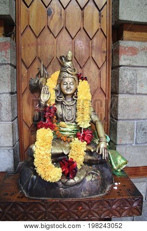 A statue of Shiva adorned with garlands of flowers