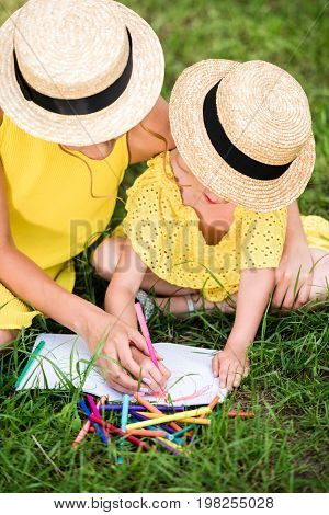 Mother And Daughter Drawing In Park