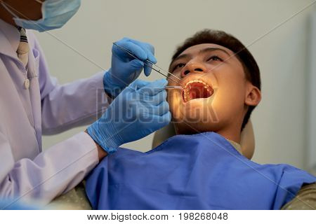 Young patient visiting dentist to have annual teeth examination
