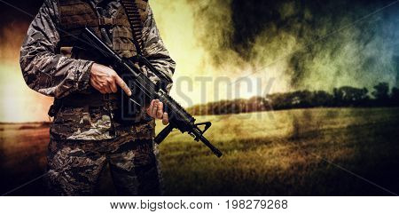 Wheat farm against military carrying a rifle 