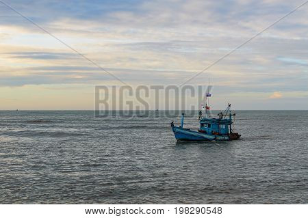 A Lonely Wooden Fishing Boat Returns To The Village After Night Catching At Dawn