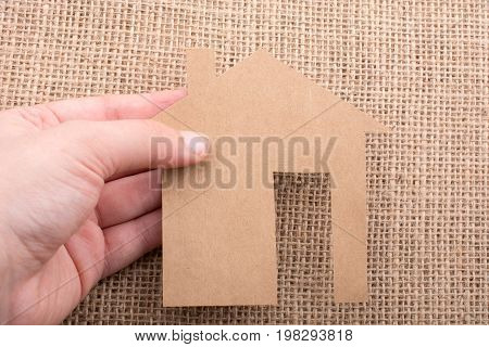 Hand Holding A Paper House On Canvas