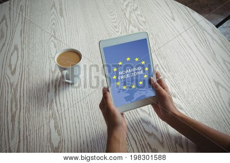 Roaming free zone text on European Union flag against cropped image of woman holding tablet