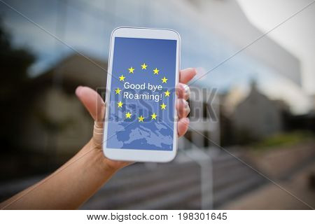 Good bye roaming text on European Union flag against woman holding mobile phone