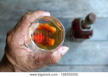 Local whiskey in a glass with bottle of herbal liquor in Thailand.