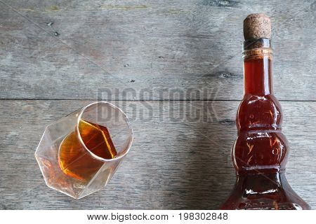 Local whiskey in a glass with bottle of herbal liquor in Thailand.