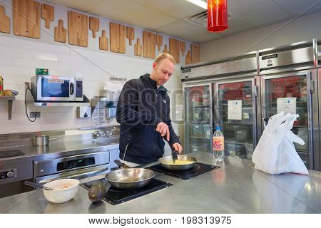 CHICAGO, IL, - CIRCA APRIL, 2016: man prepare food at Chicago Getaway Hostel. Hostels provide budget-oriented, sociable accommodation where guests can rent a bed, usually a bunk bed, in a dormitory.