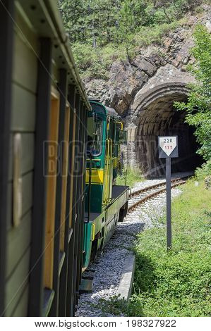Vintage Railroad Train Enters A Dark Tunnel