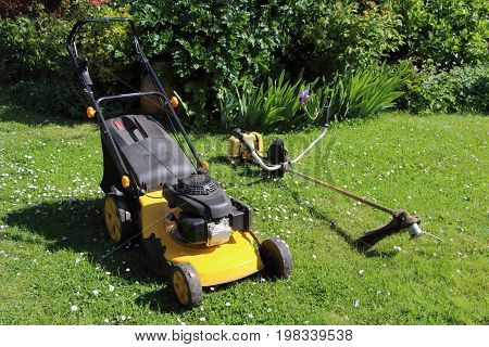 Gardening equipment mower and brush cutter in a garden during spring