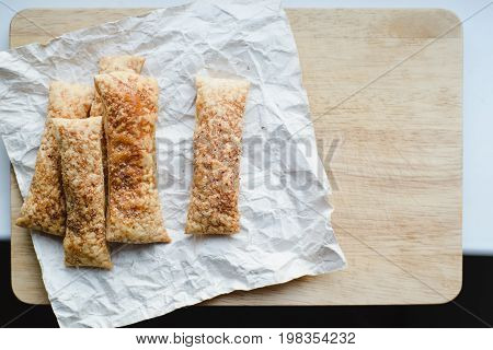 top view of homemade fresh baked puff pastry cookies on cutting board to birthday gift