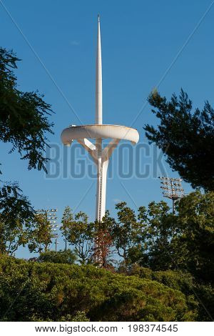 TV antenna in the Olympic park of Barcelona on the mountain of Montjuic. White futuristic antenna. Antenna designed by Santiago Calatrava. Torre de telecomunicaciones de Montjuic. Barcelona. TV Tower.