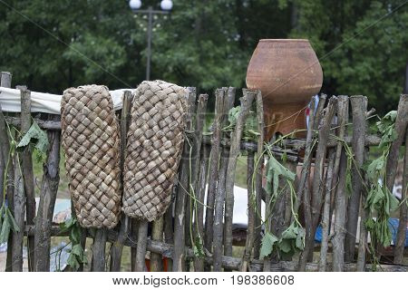 Old shoes hang on the fence and dried. Russian retro shoes.