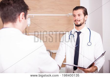 Two doctors in front of eatch other in hospital recovery room talking. Medicine and healthcare