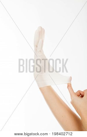 Right hand of a woman with white surgical latex glove