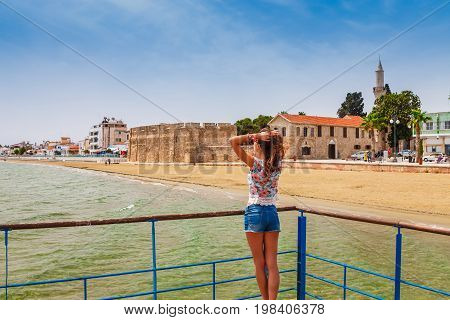 Young Tourist Woman Looking At Medieval Castle In Larnaca,cyprus. Famous Tourist Destination