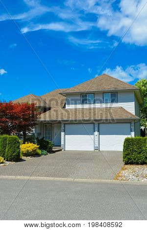 Entrance of average residential house on sunny day on blue sky background