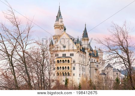 World-famous tourist attraction in the Bavarian Alps, fairytale Neuschwanstein or New Swanstone Castle, the 19th century Romanesque Revival palace at sunset, Hohenschwangau, Bavaria, Germany