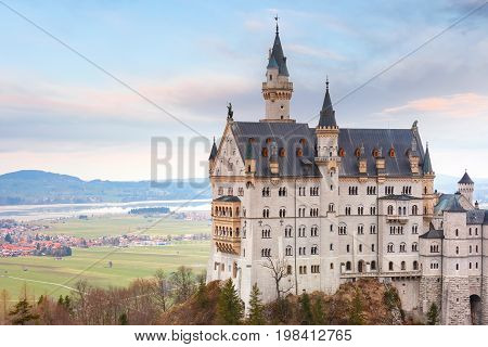World-famous tourist attraction in the Bavarian Alps, fairytale Neuschwanstein or New Swanstone Castle, the 19th century Romanesque Revival palace at sunset, Hohenschwangau, Bavaria, Germany