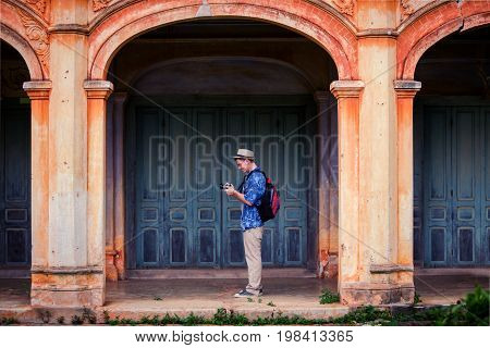 An adult handsome man touring in ancient architecture French style village in Tharae Sakon Nakhon Landmark ancient of French in Thailand.Adult handsome man tourism