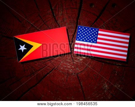 East Timorese Flag With Usa Flag On A Tree Stump Isolated