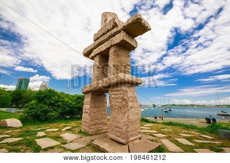 Toronto, Ontario, Canada, June 16, 2017 gorgeous amazing, inviting view of Toronto down town area outdoor park with natural landscape view and stunning inuksuk sculpture on dark blue sky background