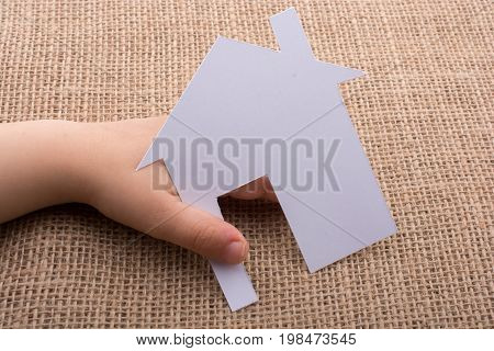 Hand Holding A Paper House On Canvas