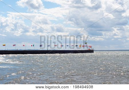 National flags of some world major global countries near the sea.