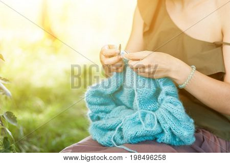 Young  Woman Knitting In Forest
