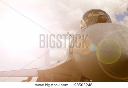 Modern jet fighter in the sky against a bright sunlight