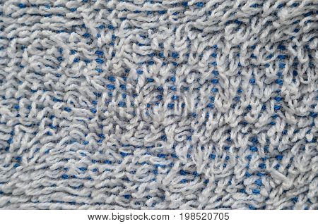 Macro shot of a white towel. Texture is similar to the texture of a fleecy knotted-pile carpet. Chaotically directed white villi on a blue basis