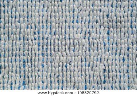 Macro shot of a white towel. Texture is similar to the texture of a fleecy knotted-pile carpet. Geometric pattern of villi on fabric material. White villi on a blue base
