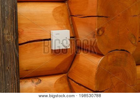 Room temperature controller for heating and cooling on a wall in a wooden house