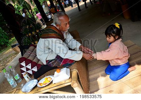 Thai Old Man Wrist Tying Thai Blessing Ceremony For Hand Of Girl