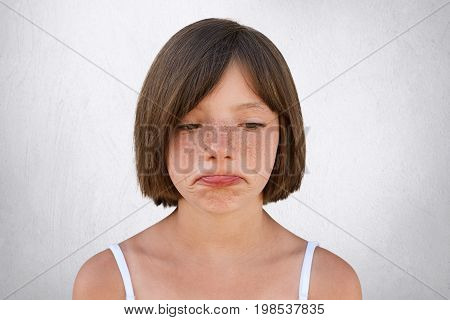 Little Upset Girl With Freckled Skin And Bobbed Hair, Curving Her Lips With Sorrorful Expression Bei