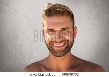 Positive Young Macho With Stylish Hairdo, Hazel Eyes, Bristle And Pleasant Smile, Demonstrating His