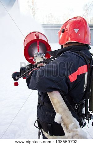 The fireman extinguishes the fire with foam