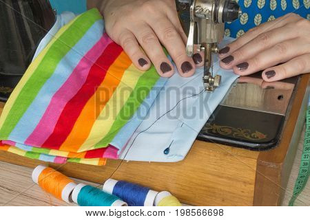 closeup of woman hands sewing yellow cloth outdoors. Woman's Hand Sewing Quilt