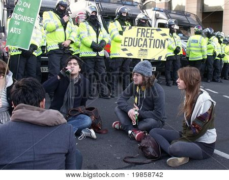 Londyn - DEC 9: Studenci demonstracji przeciwko Uniwersytetu opłata wzrasta z przodu linii policji w 