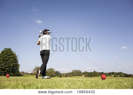 Actieve hoger vrouwelijke golfspeler swingende Golfclub tee off de bal op de prachtige golfbaan met bl